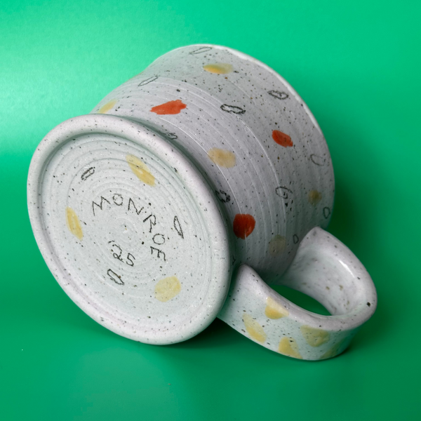 Ceramic mug with speckled pattern on a green background